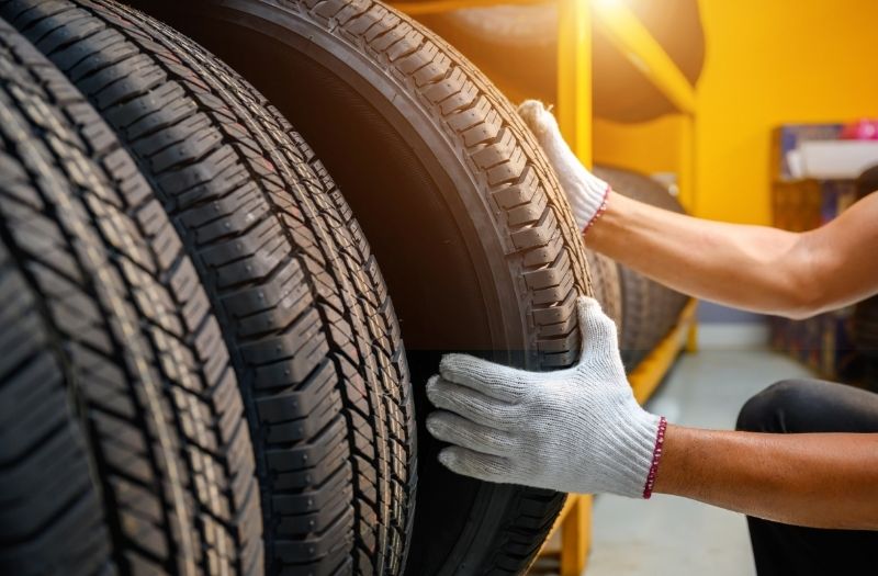 Technician in the process of checking the condition of new tires in stock.